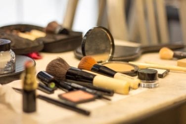 Image of powder makeup and brushes, representing some of the everyday products people use that have been known to cause asbestos-related diseases because of the asbestos found in talc.